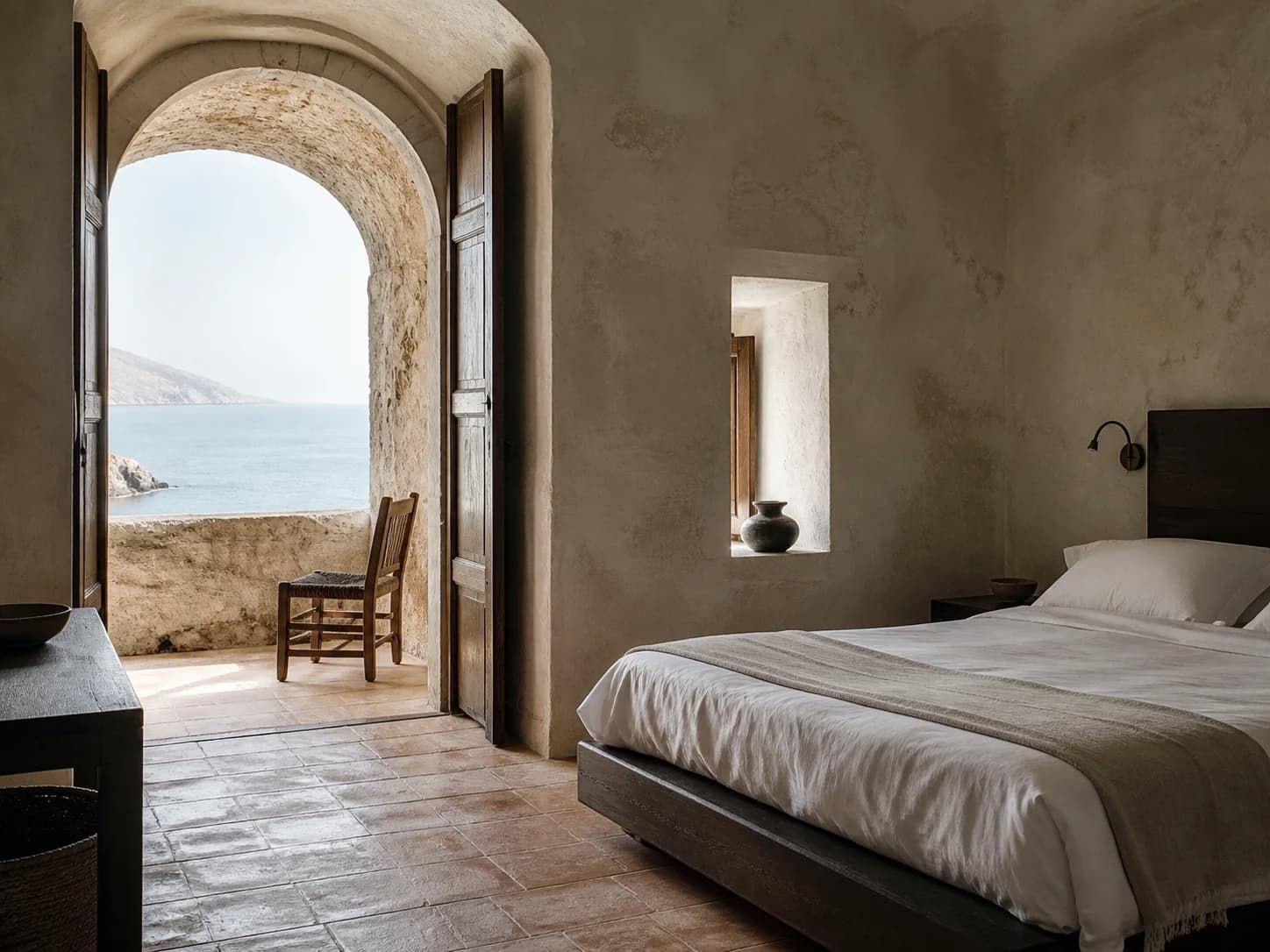 A Cliff Room at Montreval Calanera with shuttered doors open to a private loggia above the sea.