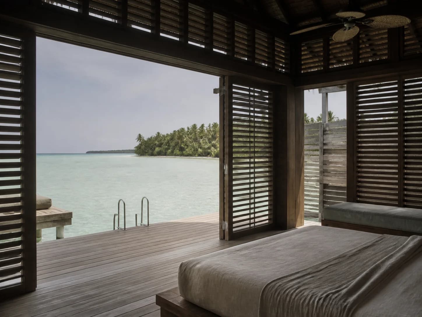 A Lagoon Villa at Montreval Tamerin standing on timber piles above pale shallow water.