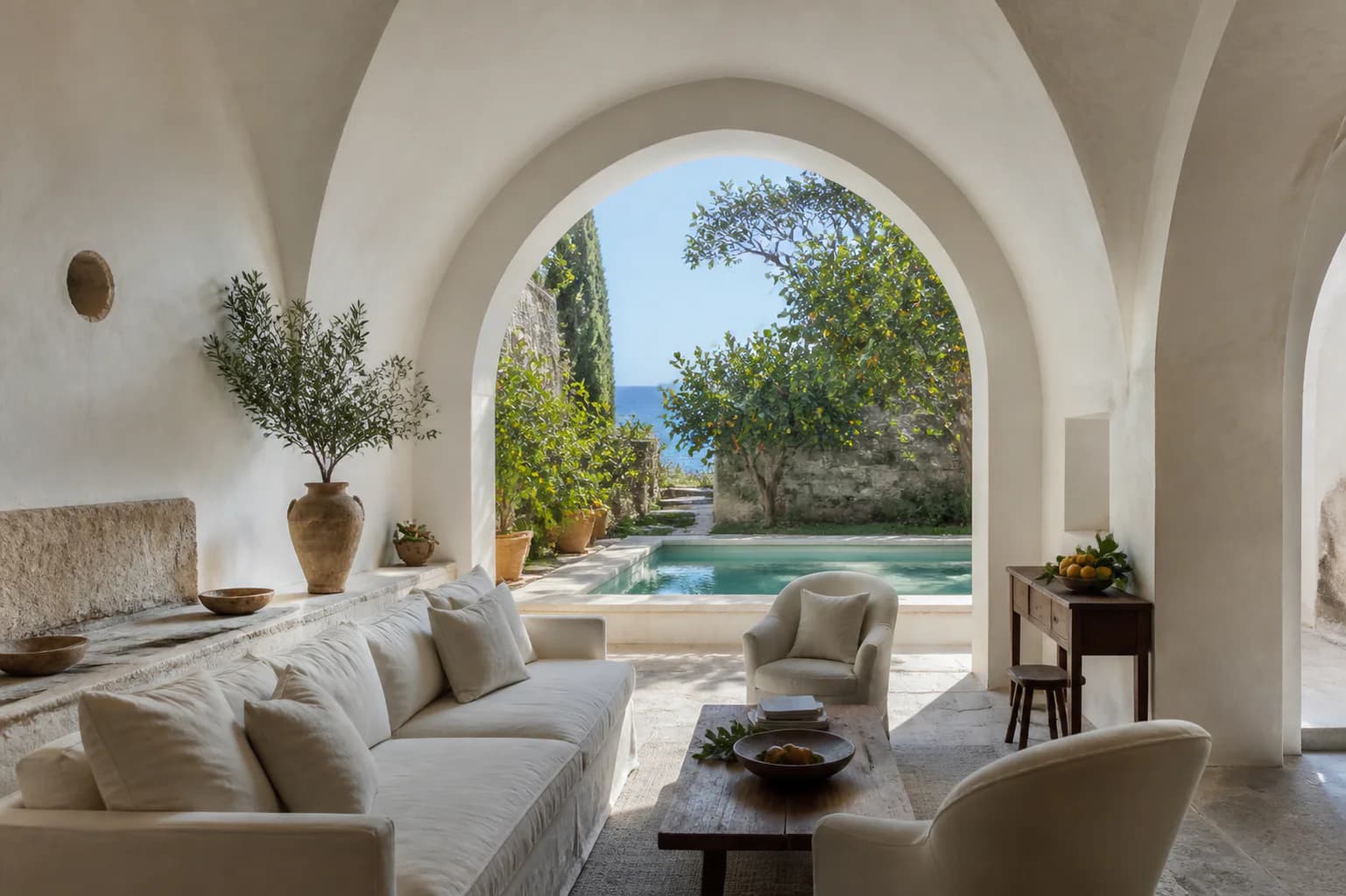 The vaulted living room of the Limonaia Suite at Montreval Calanera opening to a walled garden.