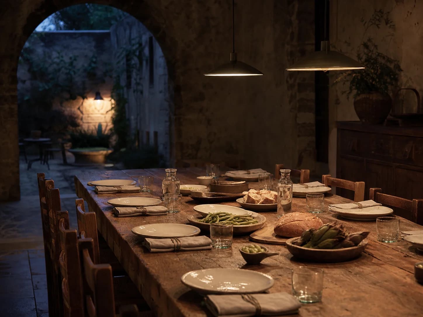 Vines under a night sky at Maison Aubris, the courtyard lit beyond.